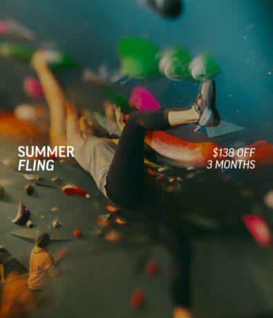 A person climbs at Minneapolis Indoor Climbing Gym Bouldering Project, surrounded by colorful holds. Text reads SUMMER FLING and $138 OFF 3 MONTHS. The dynamic, playful scene highlights this exciting promotional offer.