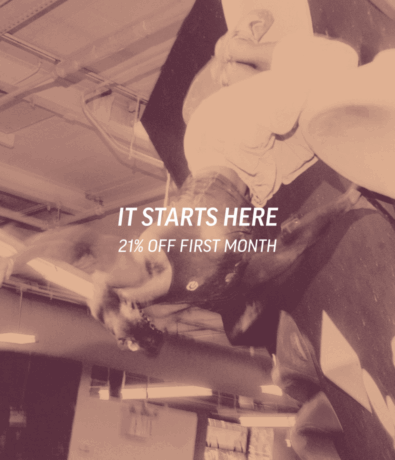 A person climbs an indoor rock wall at an Austin climbing gym. Overlaid text reads: IT STARTS HERE 21% OFF FIRST MONTH. The background shows climbing holds and the gym ceiling, all tinted with a pinkish hue.