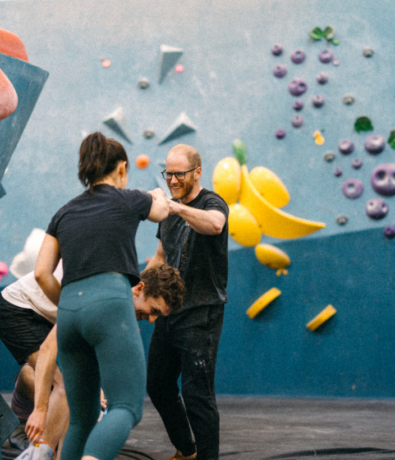 Two people fist bump while climbing in Boston