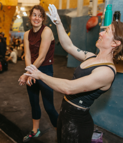 Two women learn how to climb at bouldering project