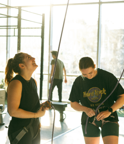Two people learn how to belay and tie figure 8 knots at Bouldering Project