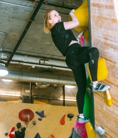 Woman finishing a climb at Bouldering Project