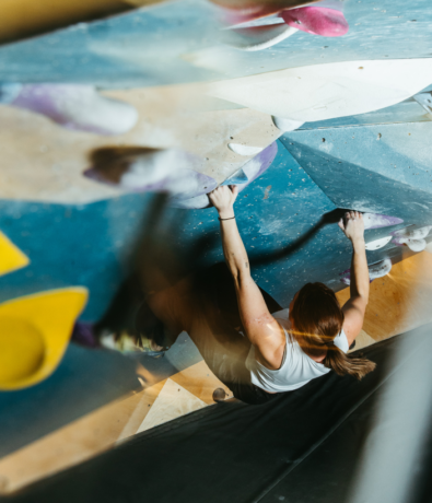 Woman climbing an overhang route at Bouldering Project