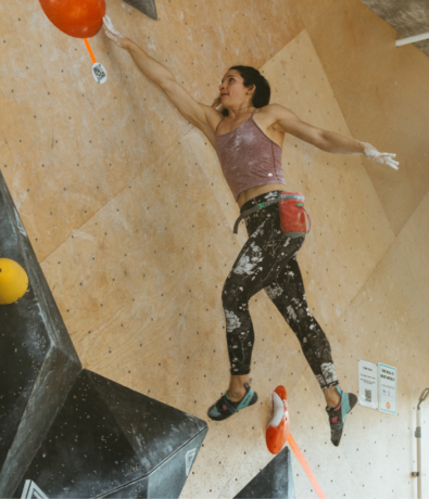 Woman catching a dyno at Bouldering Project