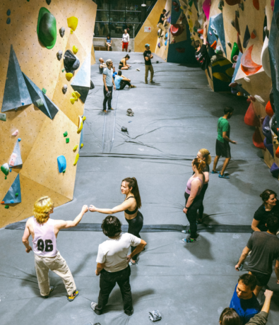 Community members fist bumping at Bouldering Project