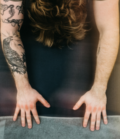 A close up shot of someones arms during child's pose in a yoga class