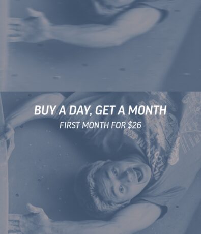 A person smiling and reaching while climbing, with text overlay: BUY A DAY, GET A MONTH. FIRST MONTH FOR $26..