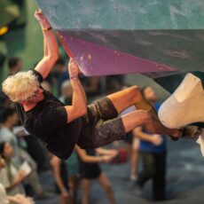 A man climbing on a wall at bouldering project