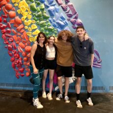 four people standing in front of a climbing wall at Bouldering Project