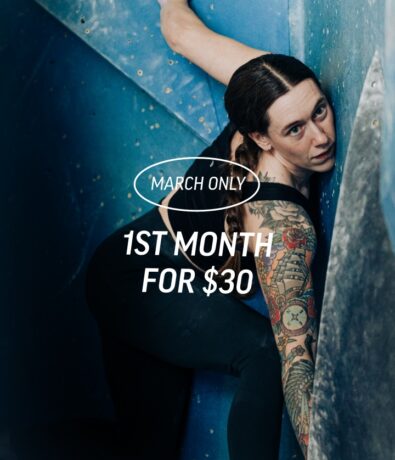 A woman with tattoos climbs an indoor rock wall at Upper Walls Fremont, looking up. Overlaid text reads: March Only 1st month for $30.