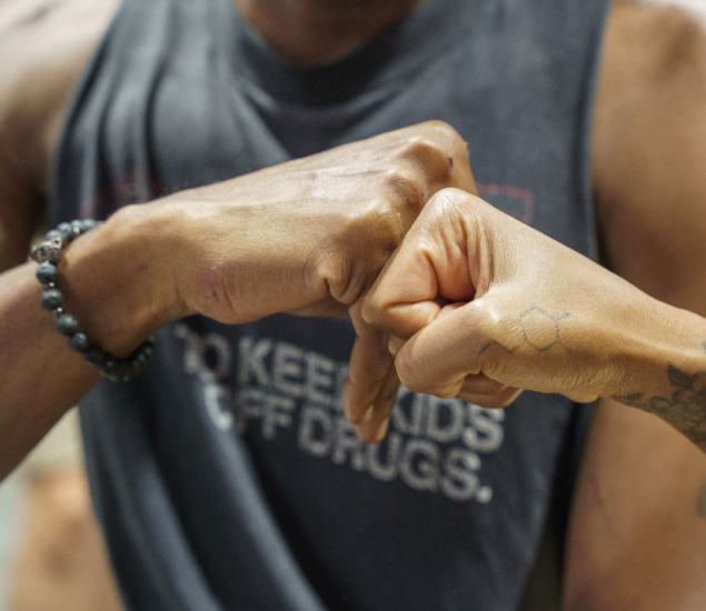 Sober climbers fist bumping at bouldering project