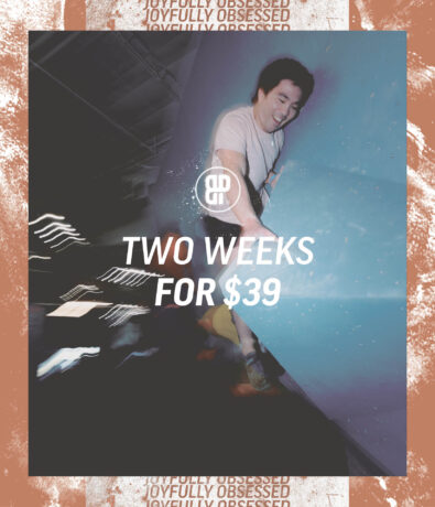 A man climbs an indoor rock wall in Austin, smiling, with motion blur behind him. Text overlay reads “Two Week Intro Pass for $39” with a circular logo above. The border features the repeated phrase Joyfully Obsessed.
