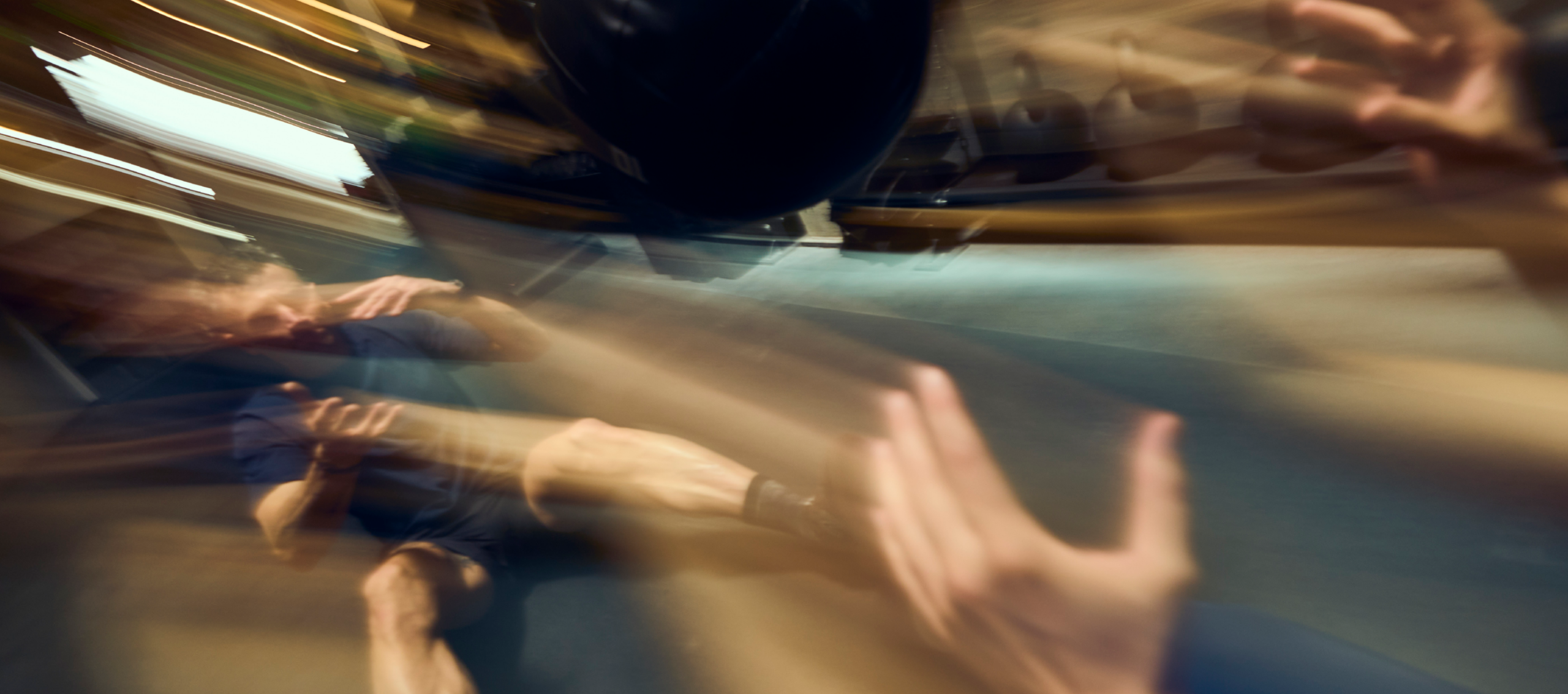 A blurred, dynamic image showing a person in athletic wear falling backward during a Fitness Challenge in an Austin gym, with motion streaks emphasizing rapid movement and outstretched hands attempting to break the fall.