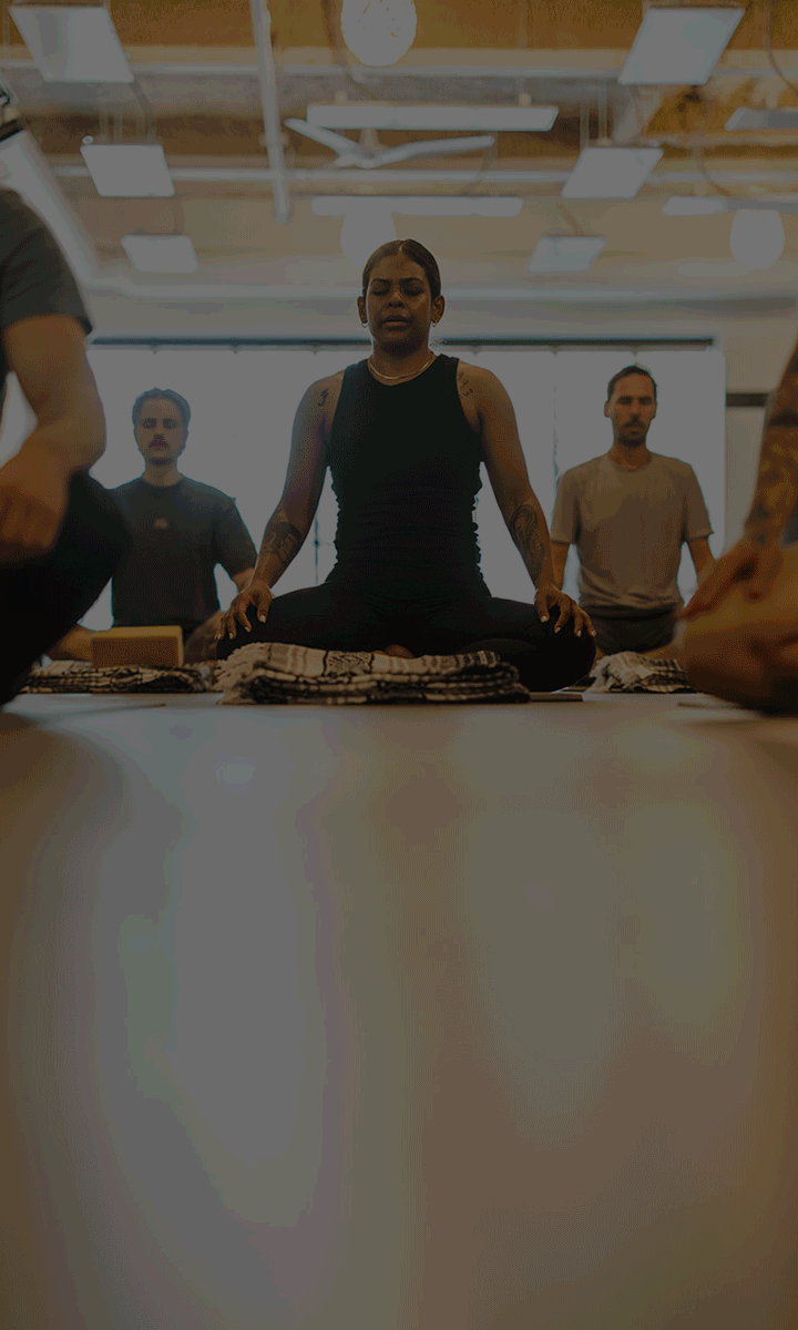 A group of people meditate in a room with bright lights and a ceiling fan, enjoying the serenity offered by their summer membership.