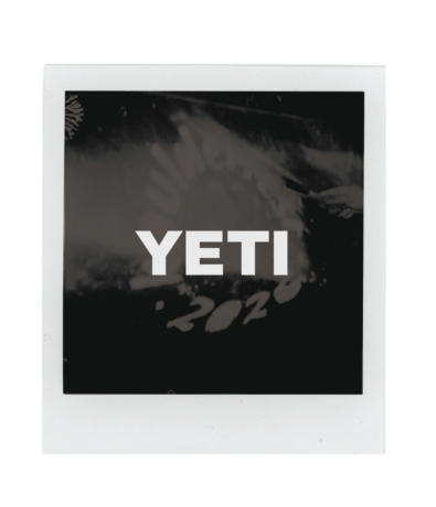 A black and white Polaroid photo with the word YETI in bold white letters centered over a blurry background, faint numbers “2020” visible—perfect for commemorating Boulderfest 2026.