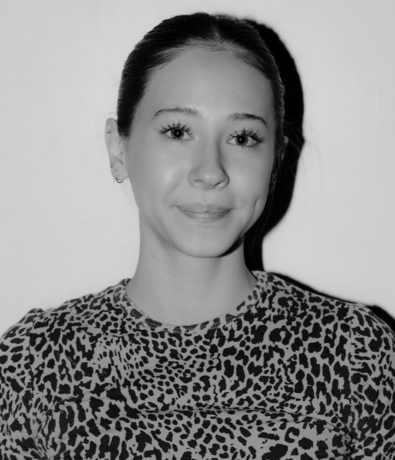 A woman with her hair pulled back wearing a leopard-print top at the Bouldering Project.
