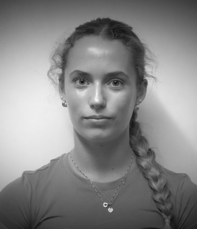 Black and white headshot of a young woman with a braided hairstyle facing forward, taken at a Bouldering Project climbing competition.