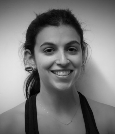 A black and white headshot of a smiling woman with her hair pulled back at a Boulderfest community climbing competition.